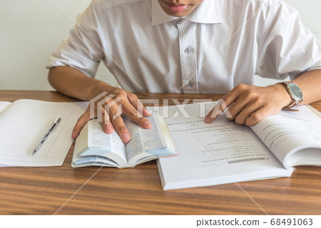Young student reading books and studying 68491063