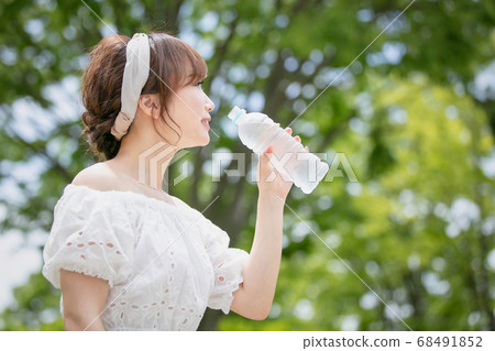 A woman drinking water A woman drinking water 68491852
