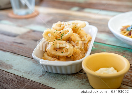 Fried squid with garlic, crispy batter, Asian street food on a wooden floor. Photos jpg 68493062
