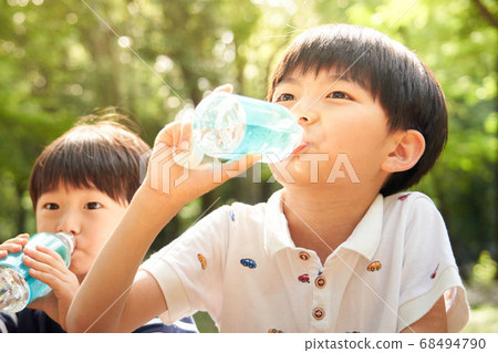 Boy drinking water in the woods Boy drinking water in the woods 68494790