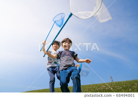 A boy running with an insect net 68494801