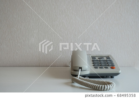 Telephone on the desk at gray wall background Telephone on the desk at gray wall background 68495358
