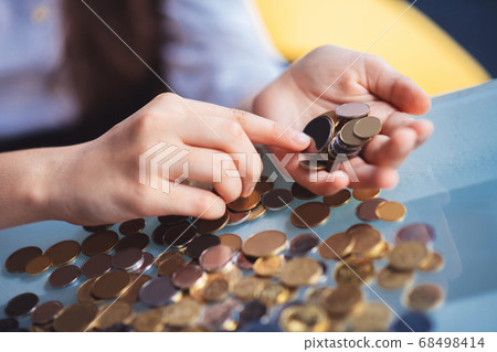 Close up picture of girls hands counting coins 68498414