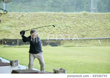 Senior man practicing on a golf course 68506745