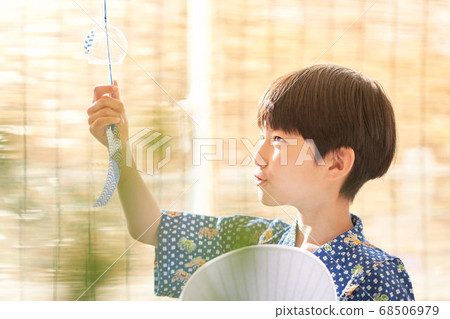 A boy staring at a wind chime A boy staring at a wind chime 68506979