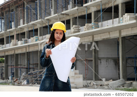 Female civil engineer or architect with yellow helmet. Female civil engineer or architect with yellow helmet. 68507202