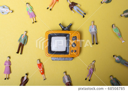 Figurine people around retro syled tiny television Figurine people around retro syled tiny television 68508785