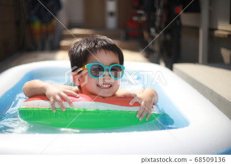 Boy playing in a plastic pool 68509136