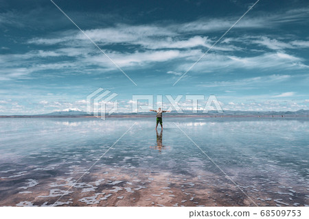 Man alone at endless salt flat Salar de Uyuni. Man silhouette and reflection in the Salar de Uyuni. Man alone at endless salt flat Salar de Uyuni. Man silhouette and reflection in the Salar de Uyuni. 68509753