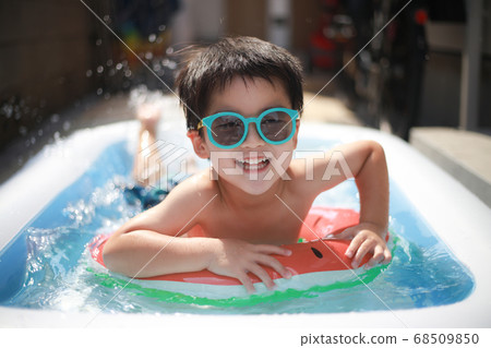Boy playing in a plastic pool 68509850