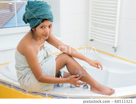 young woman creams her leg young woman creams her leg 68511321