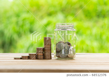Coin Stack , coin in Glass bottle  in green bokeh 68512376