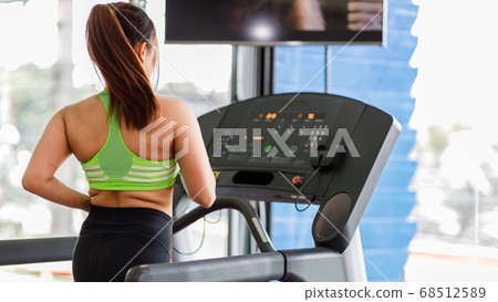 Women running in a gym on a treadmill.exercising concept. Women running in a gym on a treadmill.exercising concept. 68512589