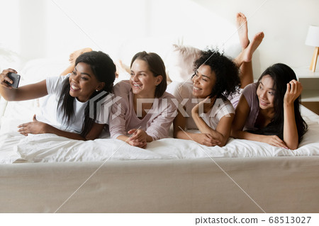 Multiethnic girls lying in bed taking selfie enjoy bachelorette party Multiethnic girls lying in bed taking selfie enjoy bachelorette party 68513027