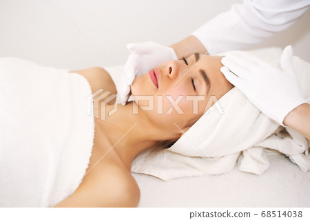 Facial massage. Beautiful young woman relaxing with hand massage in beauty spa. 68514038