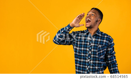 Positive Black Man Shouting Holding Hand Near Mouth, Yellow Background 68514565