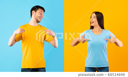Happy young man and woman pointing fingers at themselves Happy young man and woman pointing fingers at themselves 68514840