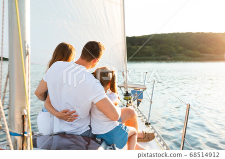 Family Enjoying Yacht Tour Sitting On Deck Sailing In Sea Family Enjoying Yacht Tour Sitting On Deck Sailing In Sea 68514912