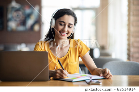 Intelligent young woman having online lessons, cafe interior Intelligent young woman having online lessons, cafe interior 68514914