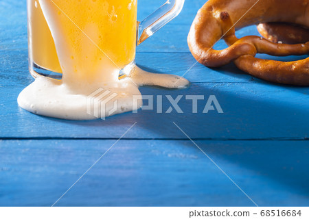 Beer glass and pretzel on blue table. German wheat 68516684