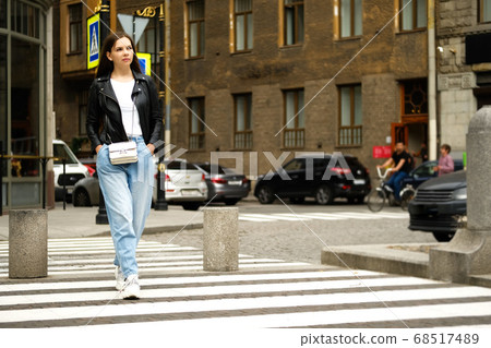 Young woman crossingthe road in old city. 68517489