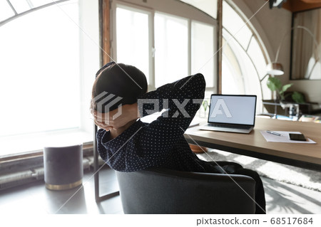 Peaceful young mixed race businesswoman relaxing in office. Peaceful young mixed race businesswoman relaxing in office. 68517684