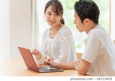 A couple using a personal computer 68519403