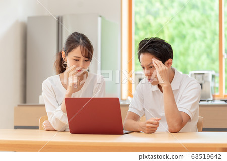 A couple thinking by looking at a personal computer A couple thinking by looking at a personal computer 68519642