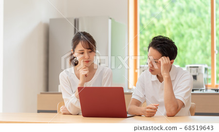 A couple thinking by looking at a personal computer 68519643