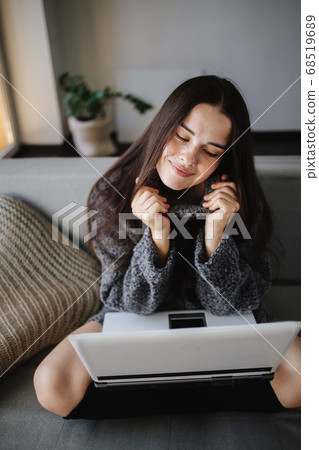 Young woman using laptop in cozy living room 68519689