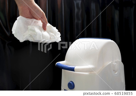 We throw the baby diaper into the waste bin. Rubbish in the trash can. 68519855