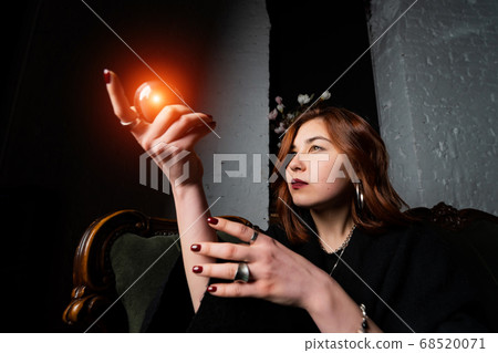 Woman in black suit holding crystal ball Woman in black suit holding crystal ball 68520071