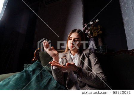 Woman in business suit holding crystal ball 68520081