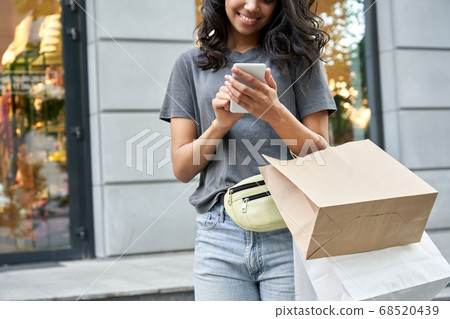 African girl shopper customer standing on street holding shopping bag and phone. 68520439