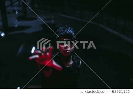 The man pulls his hand up. Cyberpunk style. Night parking. The man pulls his hand up. Cyberpunk style. Night parking. 68521105