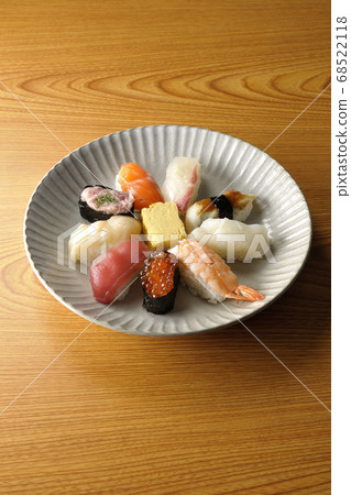 Tuna, scallop, salmon, salmon, salmon roe, sea bream, squid, conger eel, nigiri sushi rolls served on a round flat plate 68522118