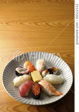 金槍魚，扇貝，鮭魚，鮭魚，鮭魚子，鯛魚，魷魚，鰻魚，握壽司卷裝在一個圓形的平板上 68522122