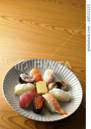 金槍魚，扇貝，鮭魚，鮭魚，鮭魚子，鯛魚，魷魚，鰻魚，握壽司卷裝在一個圓形的平板上 68522123