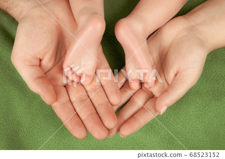 the feet of a newborn baby lie in the arms of his parents the feet of a newborn baby lie in the arms of his parents 68523152