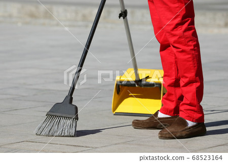 the janitor sweeping the tiles in the city. the janitor sweeping the tiles in the city. 68523164