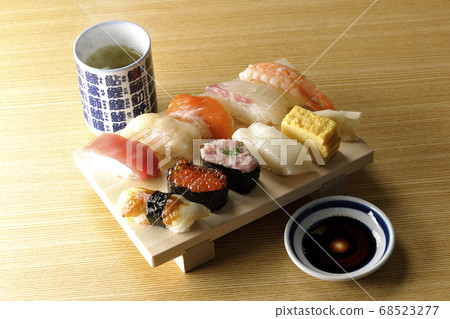 壽司金槍魚上的木log,扇貝,鮭魚,鮭魚,鮭魚卵,鯛魚,魷魚,鰻魚,握壽司和熱茶。 壽司金槍魚上的木log,扇貝,鮭魚,鮭魚,鮭魚卵,鯛魚,魷魚,鰻魚,握壽司和熱茶。 68523277