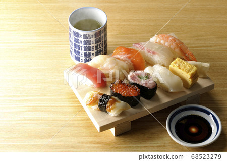 壽司金槍魚上的木log，扇貝，鮭魚，鮭魚，鮭魚卵，鯛魚，魷魚，鰻魚，握壽司和熱茶。 68523279