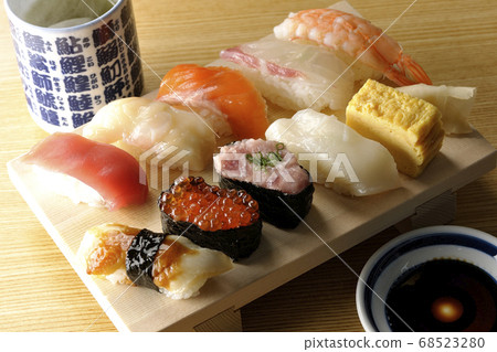 Sushi Tuna on the clogs, scallops, salmon, salmon, salmon roe, sea bream, squid, conger eel, nigiri sushi and hot tea. 68523280