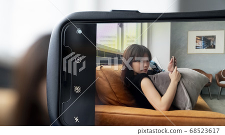 A woman photographed on a smartphone 68523617