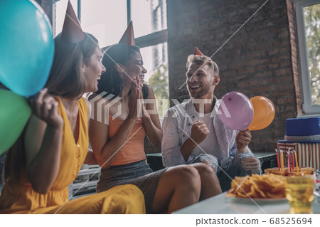 Happy friends laughing while having a birthday party Happy friends laughing while having a birthday party 68525694