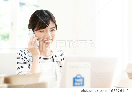 A woman in the food and drink business who takes orders for takeout [smartphone] 68526141