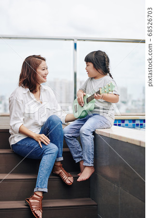 Little girl singing for mother 68526703