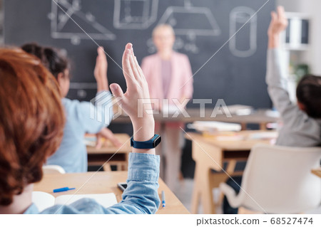Arms of clever pupils willing to answer question of teacher by blackboard 68527474