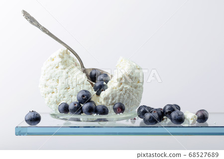 Cottage cheese with blueberries on a white Cottage cheese with blueberries on a white 68527689