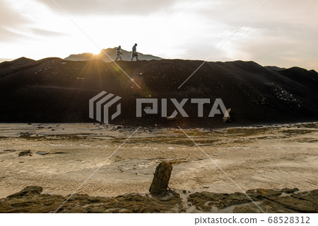 Tiny silhouettes of two contemporary researchers moving along hilltop Tiny silhouettes of two contemporary researchers moving along hilltop 68528312